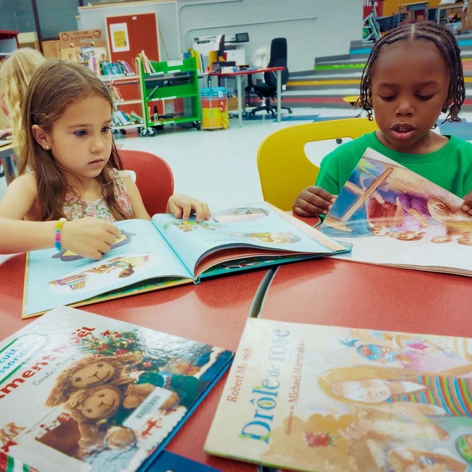 jeunes élèves à une table qui lisent des livres